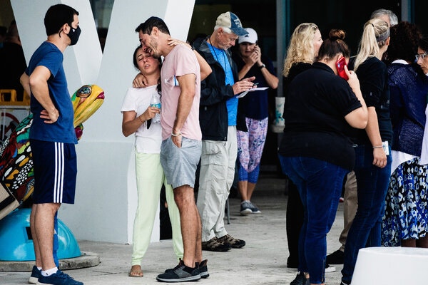 People gather at Surfside Community Center, which is acting as a reunification center, as they wait for information.